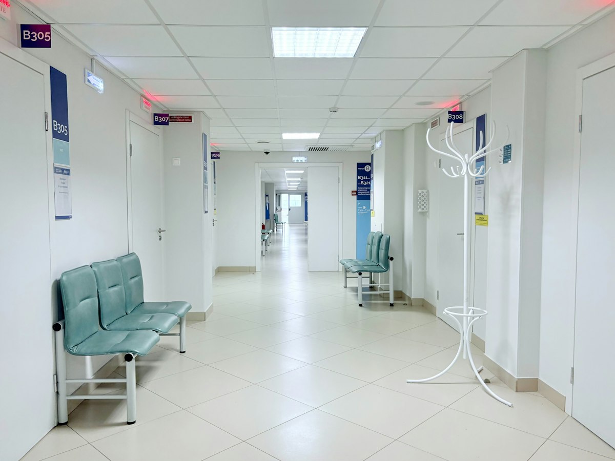 Couloir de clinique avec salles de consultation et espace d'attente